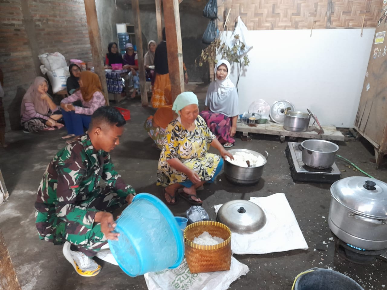 Anggota Satgas TMMD Bantu Masak Warga
