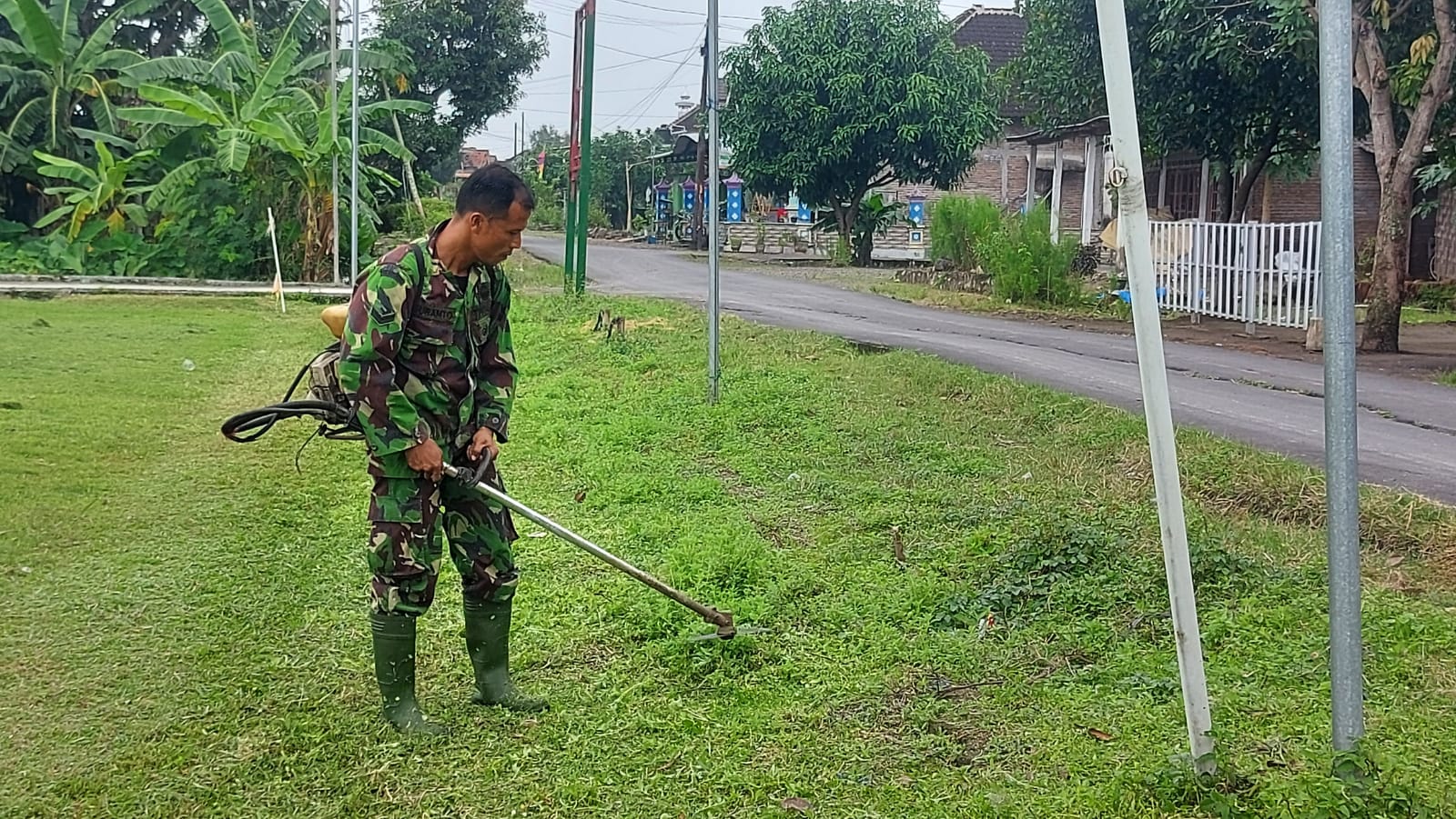 Persiapan Penutupan TMMD Anggota Satgas Memotong Rumput Lapangan Desa Gedongan