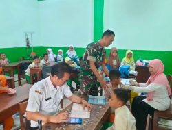 Sertu Marwan Seorang Babinsa yang Hangat dan Penuh Perhatian Membantu Menenangkan Anak-Anak Selama Bulan Imunisasi di Sekolah