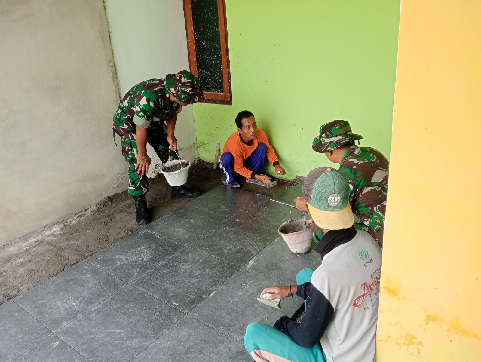 Kepedulian Babinsa, Bantu Pemasangan Keramik Rumah Warga
