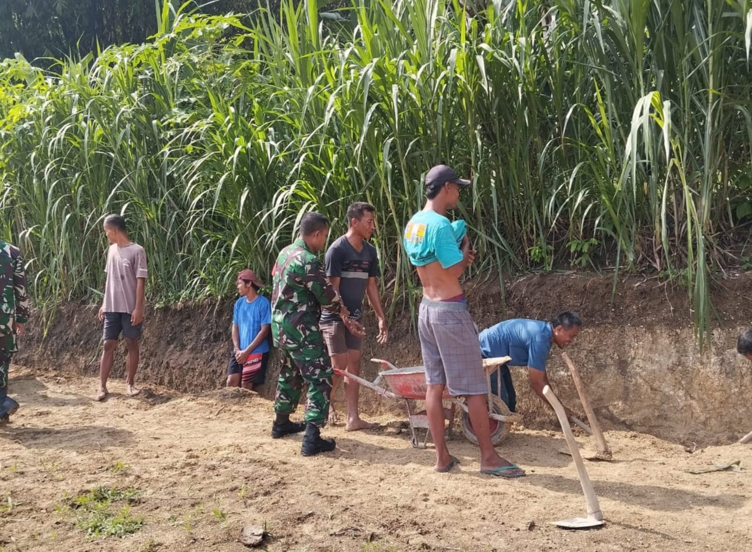 Babinsa dan Warga Bergotong Royong Meratakan Timbunan Tanah