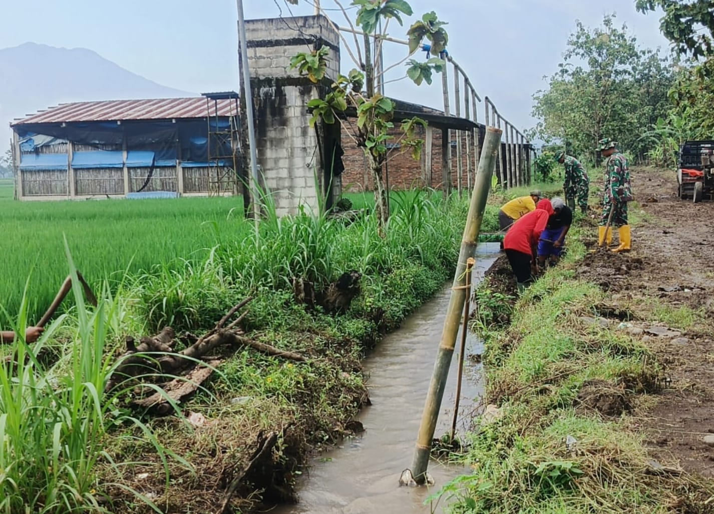 Menjaga Air Tetap Lancar, Babinsa Gotong Royong Bersihkan Saluran Irigasi