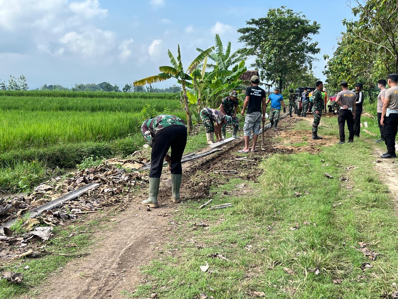 Anggota Satgas TMMD Menarik Tali Benang Untuk Menjaga Kelurusan Jalan