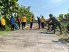 Anggota Satgas TMMD Menggaris Jalan Beton Supaya Tidak Licin