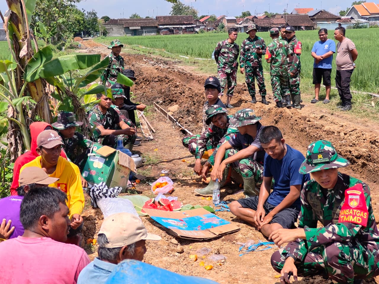 Dansatgas TMMD dan Warga Nikmati Waktu Istirahat Bersama